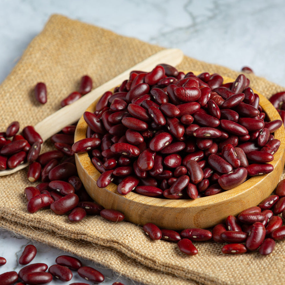 Red beans - rajma in a wooden bowl and on a wooden spoon with a burlap cloth background
